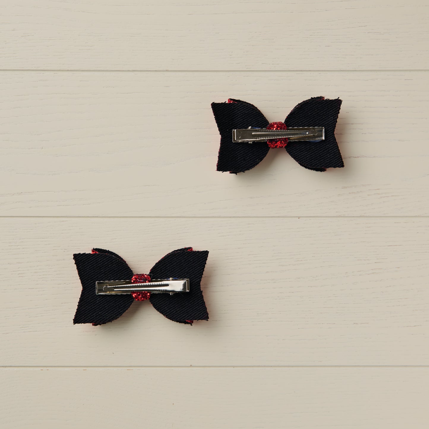 photo showing the back of the bows with alligator clips attached on a light wooden background