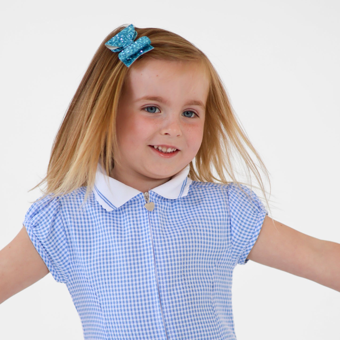 a girl twirling in her school uniform and a sparkly hair bow in her hair