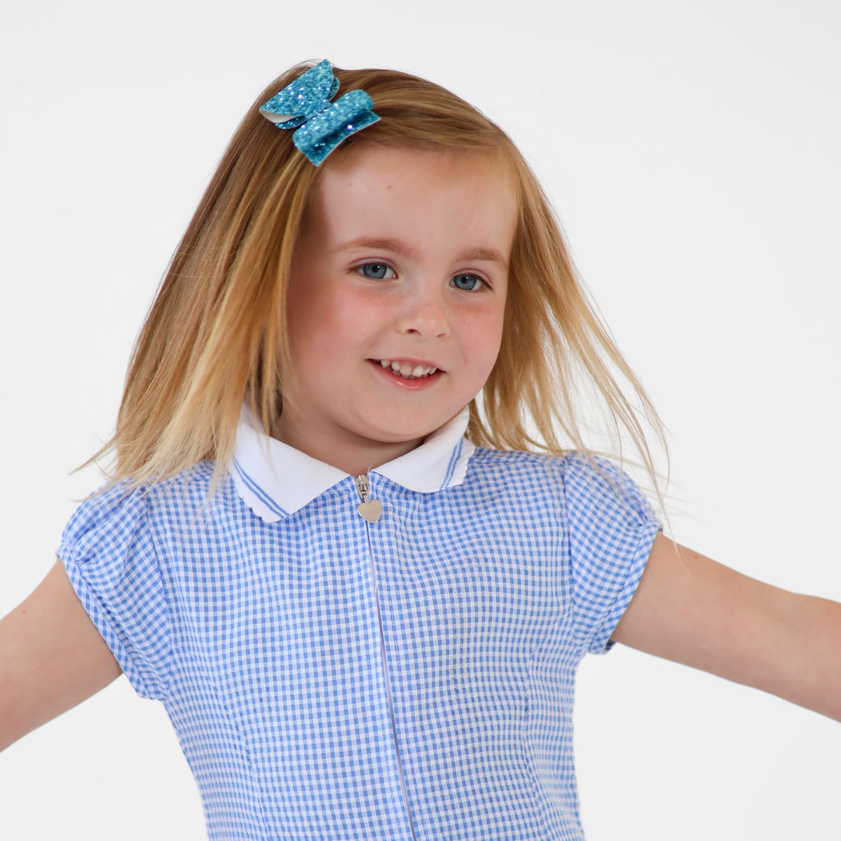 a girl twirling in her school uniform and a sparkly hair bow in her hair