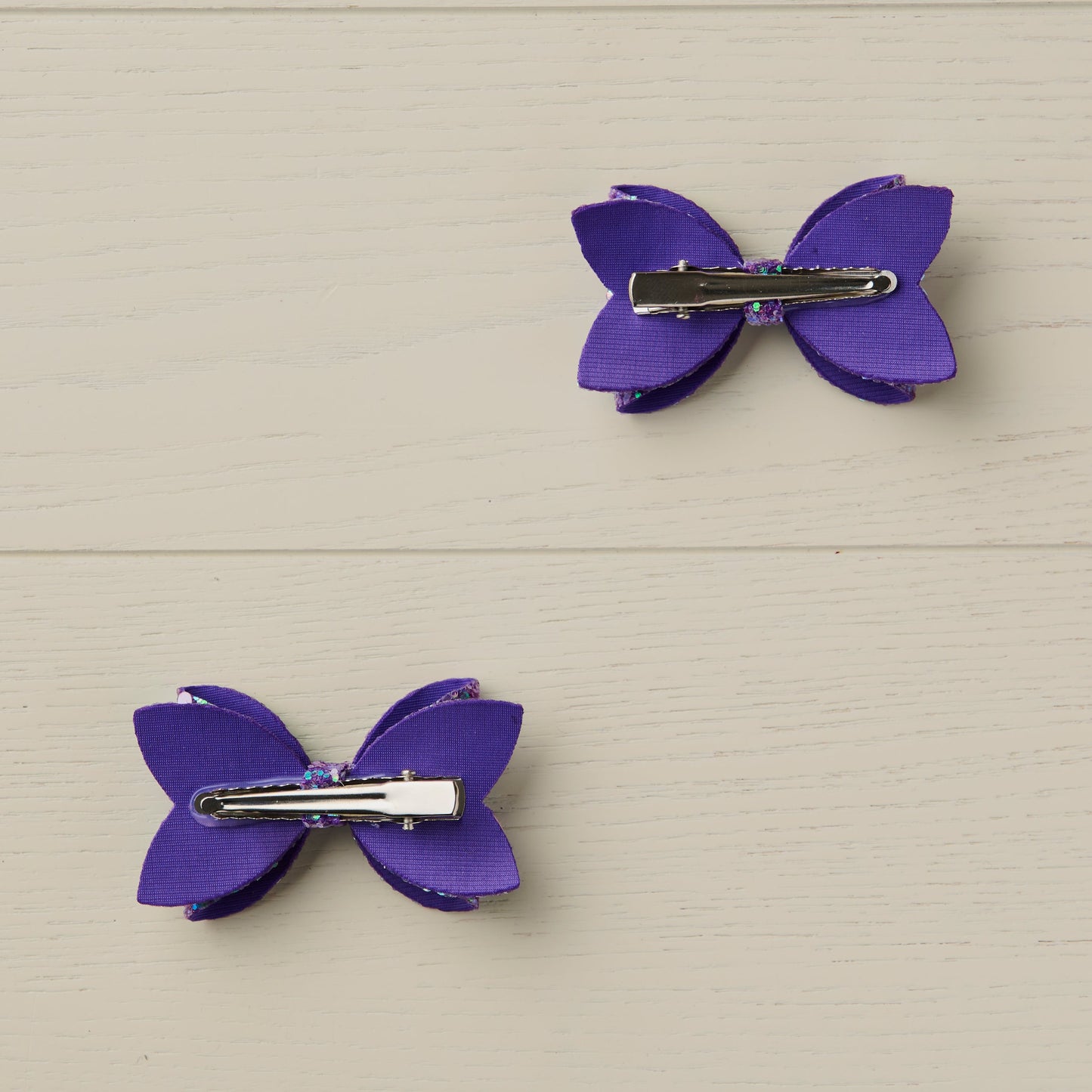 photo showing the backs of the bows with the curved alligator clips