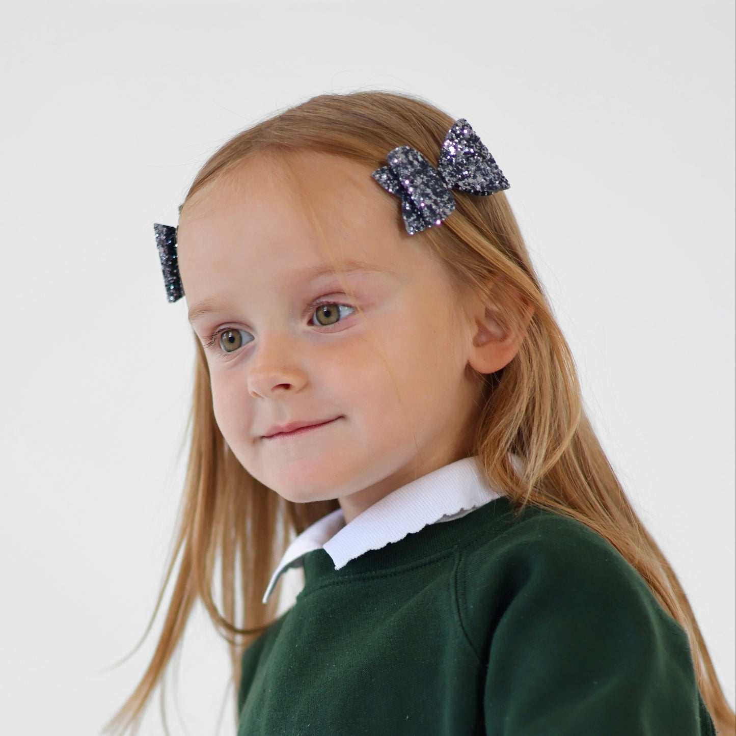 A girl wearing dark silver mini glitter bows with her school uniform