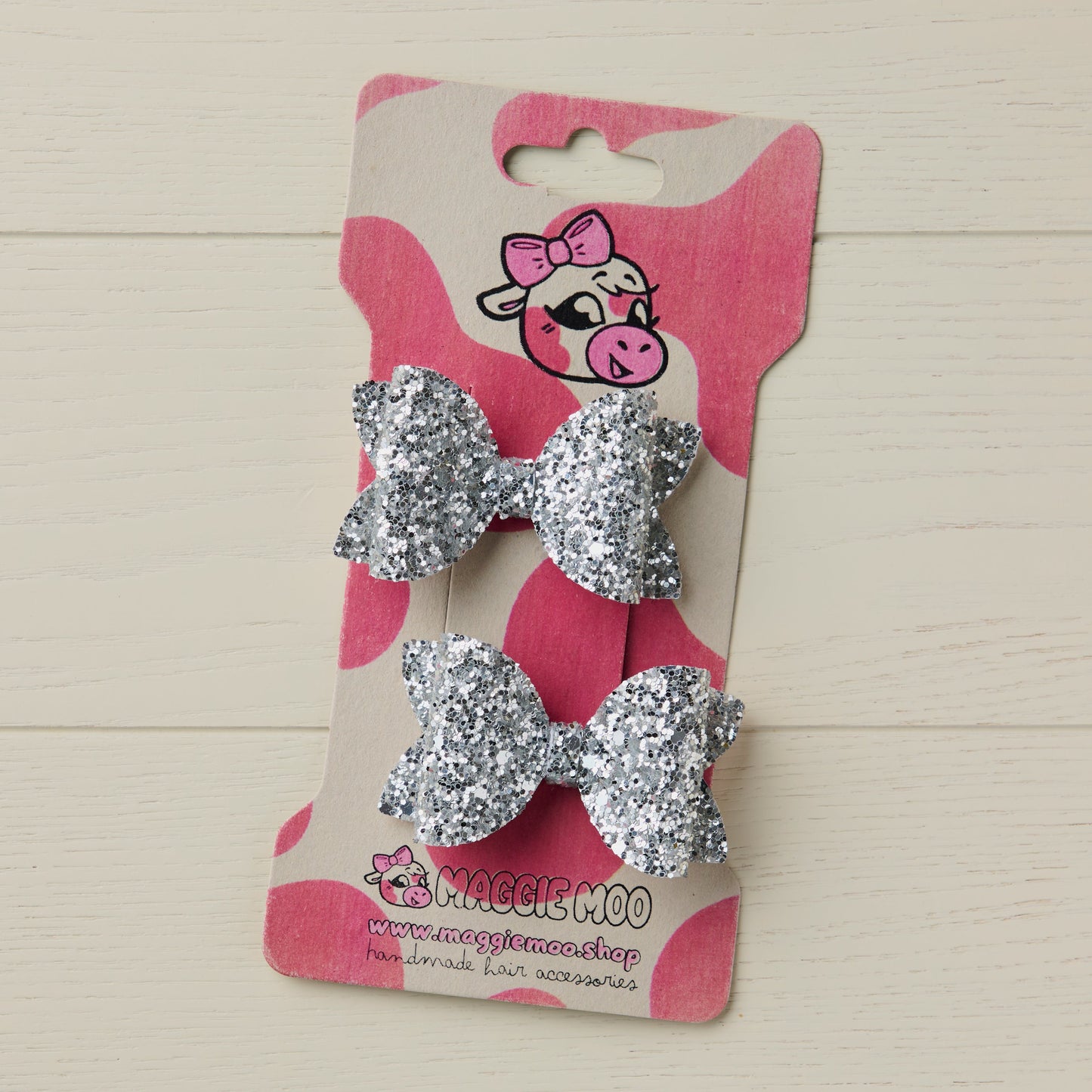 sparkly siler mini glitter hair bows on a display card with a cute cow logo