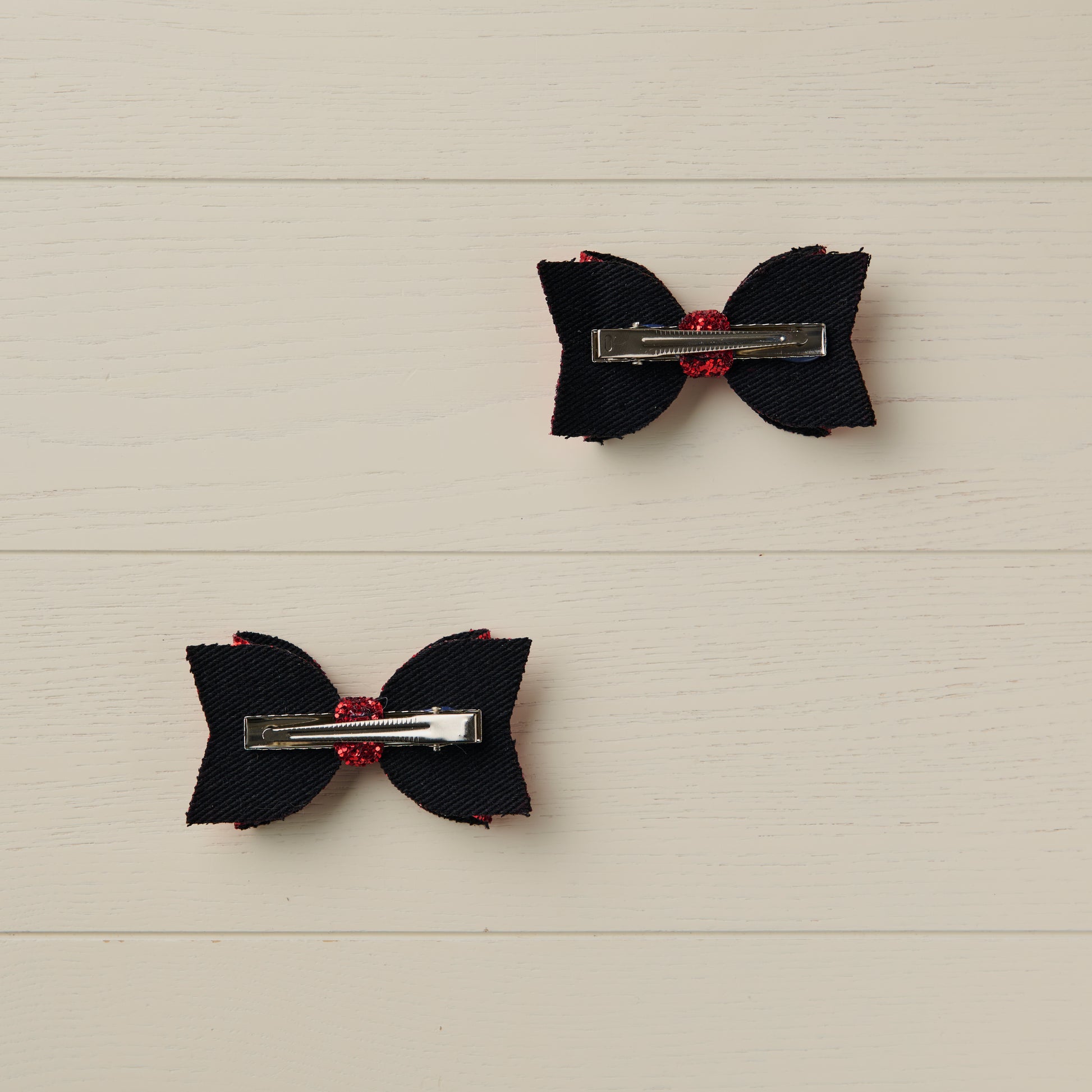 photo showing the back of the bows with alligator clips attached on a light wooden background