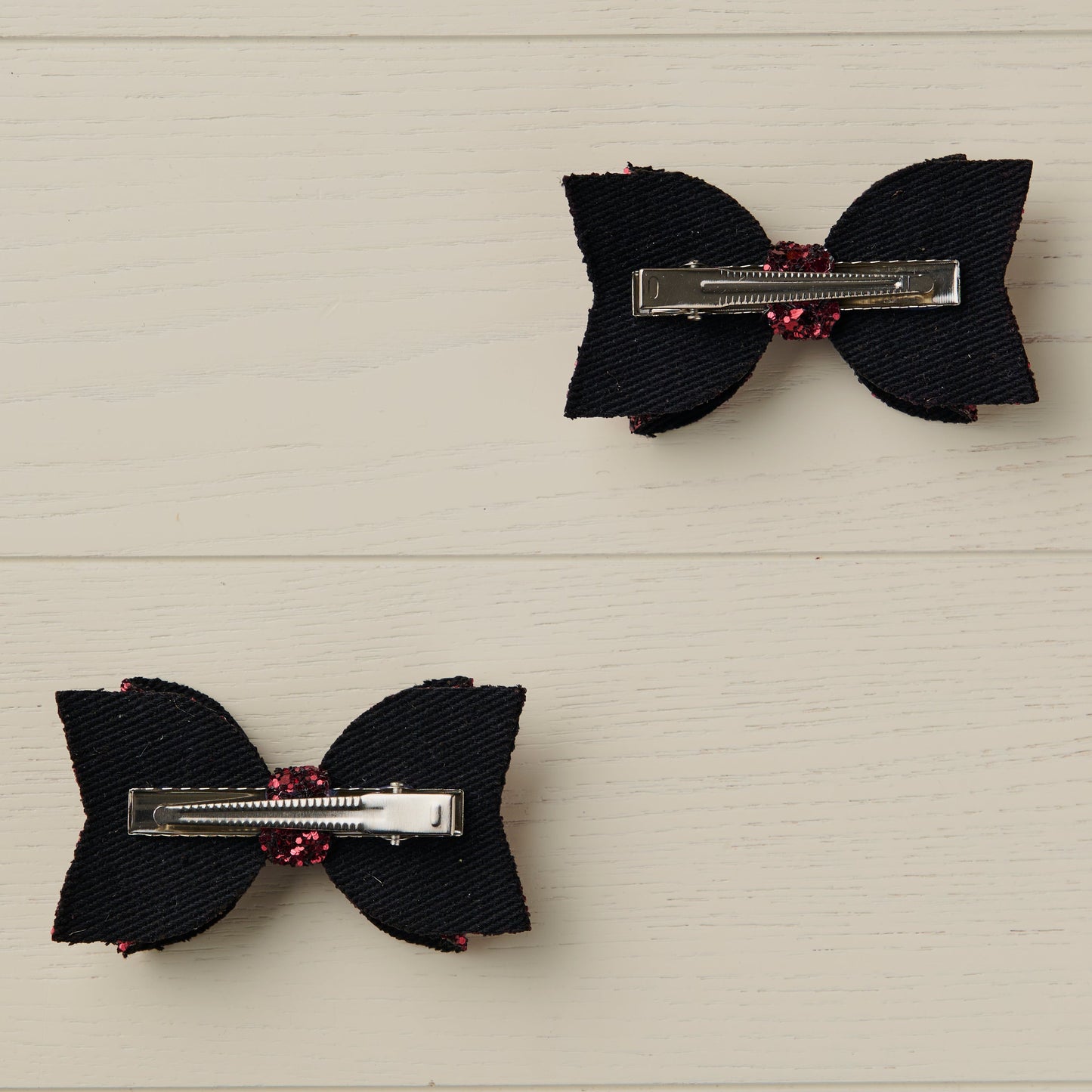 photo showing the back of the hair bows with alligator clips on a light wooden surface