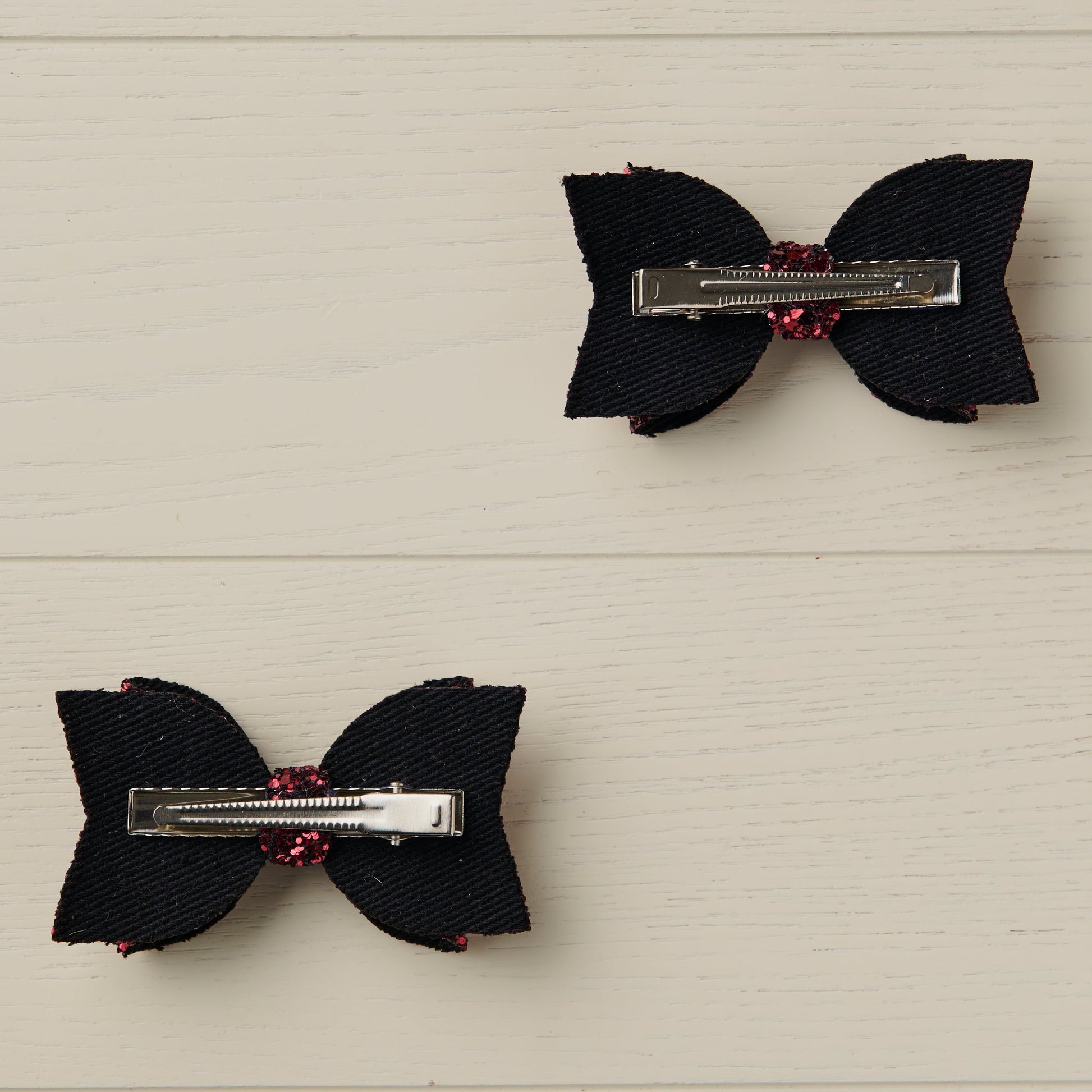 photo showing the back of the hair bows with alligator clips on a light wooden surface