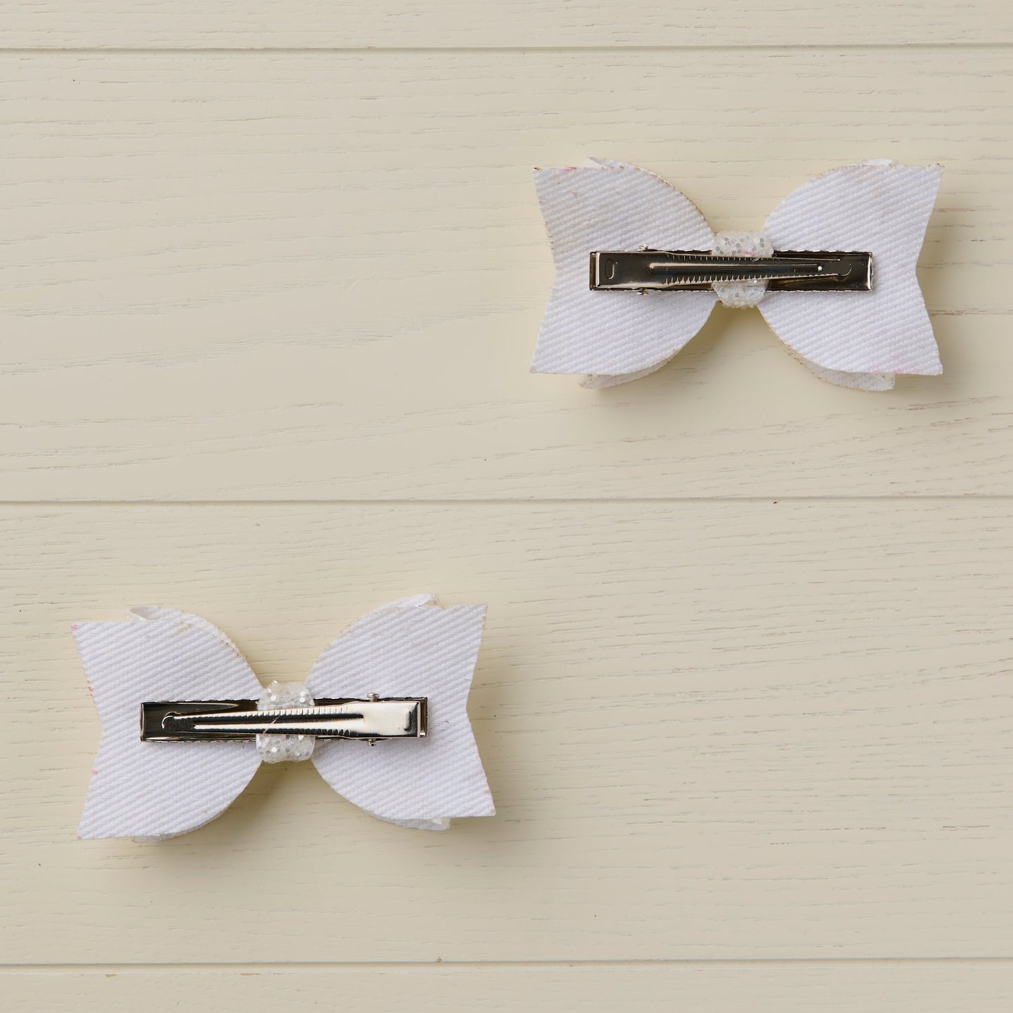 photo showing the back of the bows with flat alligator clips on a light wooden surface